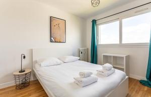 een slaapkamer met een wit bed en handdoeken bij L'Horizon appartement 3 chambres moderne - 6 pers in Rennes