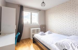 een slaapkamer met een witte bakstenen muur en een bed bij L'Horizon appartement 3 chambres moderne - 6 pers in Rennes