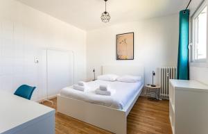 een witte slaapkamer met een bed en een spiegel bij L'Horizon appartement 3 chambres moderne - 6 pers in Rennes