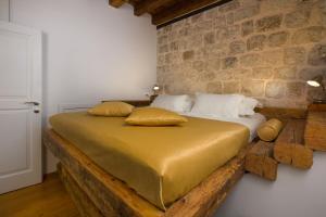 a bed in a room with a brick wall at Nije Preša Apartments in Dubrovnik