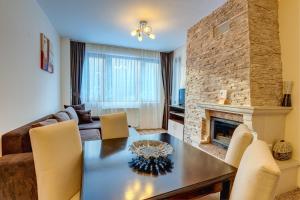 a living room with a table and a fireplace at Complex Kamelia in Pamporovo