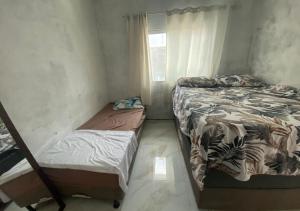 - une chambre avec 2 lits et une fenêtre dans l'établissement Casa temporada Arembepe Ba, à Camaçari