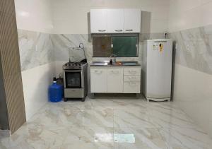 Il comprend une cuisine équipée d'un réfrigérateur et d'une cuisinière. dans l'établissement Casa temporada Arembepe Ba, à Camaçari