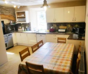 a kitchen with a table and chairs and a kitchen with a table and a table at Rhostwarch Old Farmhouse Eglwyswrw in Eglwyswrw