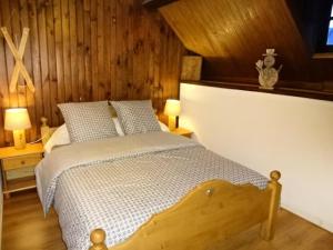 a bedroom with a bed with a wooden wall at Résidence Maison Mitoyenne - Maison 10 personnes village de GUCHEN MAE-9594 in Guchen