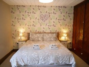 1 dormitorio con 1 cama con 2 toallas en Rhostwarch Old Farmhouse Eglwyswrw, en Eglwyswrw