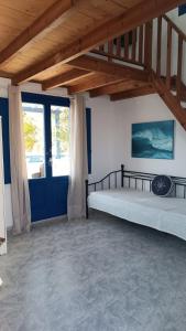 a bedroom with two beds and a blue door at BlackBeach village in Perissa