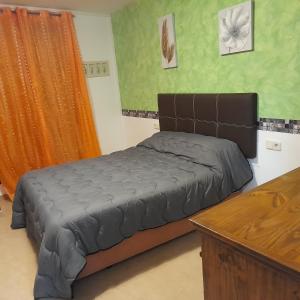 een slaapkamer met een bed en een houten tafel bij Plaza de Chinchón. Apartamento. in Chinchón