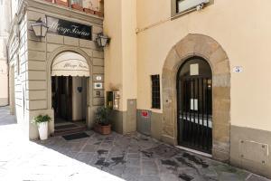 una entrada a un edificio con dos puertas arqueadas en Albergo Firenze, en Florencia