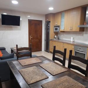 een woonkamer met een tafel en stoelen en een keuken bij Plaza de Chinchón. Apartamento. in Chinchón