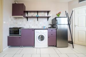 a kitchen with purple cabinets and a washer and dryer at Funky apartment in Studentski Grad in Sofia