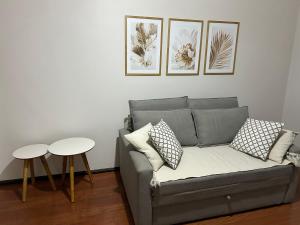a living room with a couch and two tables at Apartamento Centro ao lado do Country Club in Nova Friburgo