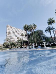 un gran edificio con palmeras y una piscina en Sea Apartment, en Alicante