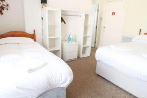 a bedroom with two white beds and white shelves at Farina No8, 3 bedroom Sea view apartment sleeping 7 guests in Bridlington