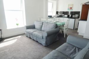a living room with a couch and a table at Farina No8, 3 bedroom Sea view apartment sleeping 7 guests in Bridlington +9 photos