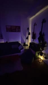 a dark room with a couch and two guitars on the wall at Parkside Modern Haven - Spacious & Serene in Košice in Košice