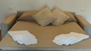 een bank met twee kussens en twee handdoeken erop. bij La Taverna di Maria in Suvereto
