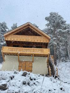 un edificio de madera en la nieve con nieve cayendo en Chalet Station Puyvalador en Puyvalador