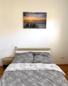 een slaapkamer met een bed met een foto aan de muur bij Vila Bösdorf Apartments in Rätzlingen