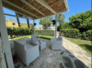 patio con 2 sedie bianche sotto un padiglione di Athena Casa Vacanze a Numana