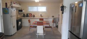 een keuken met een tafel en stoelen en een koelkast bij Chez Gilou in Rivière