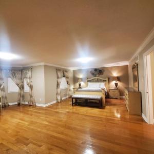 a large bedroom with a bed and a wooden floor at 4 Bedroom House in Mississauga in Mississauga