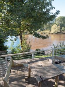 a wooden picnic table sitting next to a river at By the River in Glasbury