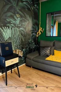 a living room with a couch and a table with a laptop at MAISON "Jungle House" 90 m2 BILLARD, RÉTROPROJECTEUR, BAR À JEUX , VINYLE, WIFI FIBRE, idéal PRO & FAMILLE à Montbrison in Montbrison