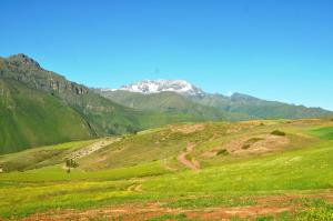 una colina verde con una montaña cubierta de nieve en el fondo en Pampachayoq - Mountain retreat, en Urubamba