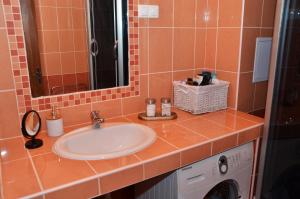 a bathroom with a sink and a washing machine at Makra-tető Öregtölgy Apartman in Pécs +36 photos