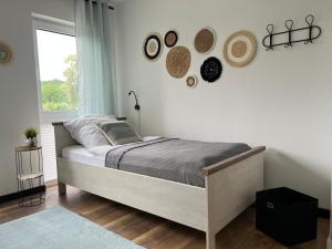 sypialnia z łóżkiem i kapeluszami na ścianie w obiekcie Große Wohnung & Apartment Sauna & 4 Badezimmer Netflix w mieście Petershagen