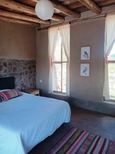 ein Schlafzimmer mit einem großen Bett und einem Fenster in der Unterkunft Pampachayoq - Mountain retreat in Urubamba