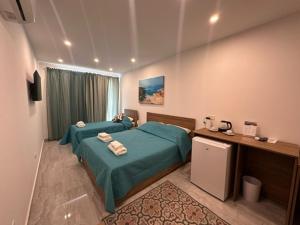 a hotel room with two beds and a desk at La Bella Guesthouse in St. Julianʼs