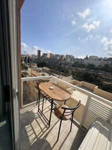 a table and chairs on a balcony with a view at La Bella Guesthouse in St. Julianʼs