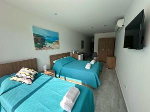 a bedroom with two beds and a flat screen tv at La Bella Guesthouse in St. Julianʼs