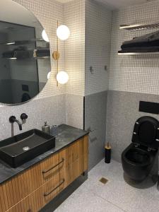 a bathroom with a sink and a toilet and a mirror at Sima suite 3 in Ashdod