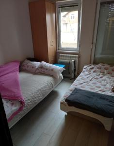 - une chambre avec 2 lits et une fenêtre dans l'établissement 2Anna Apartments, à Surčin