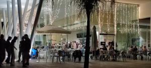 a group of people walking around a restaurant with christmas lights at Relax & Play Panoramic Golf Vinaroz, Sant Jordi Apartment in Vinaròs +78 photos