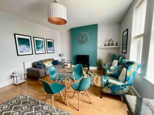 a living room with blue chairs and a couch at Between beach & shops - Private parking en-suite in Portsmouth