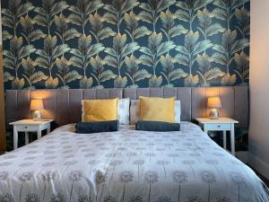 a bedroom with a large bed with a floral wallpaper at Between the Beach and Shops 2 bath private parking in Portsmouth