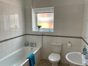 a bathroom with a tub and a toilet and a sink at Between beach & shops - Private parking en-suite in Portsmouth