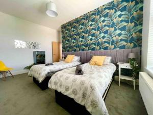 a bedroom with two beds and a wall with a mural at Between beach & shops - Private parking en-suite in Portsmouth