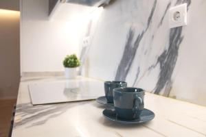 deux tasses à café assises sur un comptoir dans une pièce dans l'établissement Marquês City Center Flat, à Porto