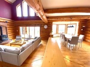 ein Wohnzimmer mit einer Couch und einem Tisch und Stühlen in der Unterkunft Privacy @ Bras d’Or Lakes Sun House Chalet in St. Peter's