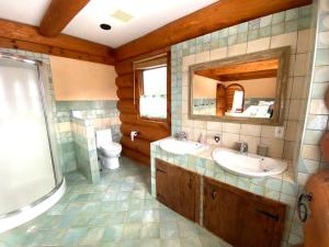 ein Badezimmer mit zwei Waschbecken und einer Toilette und einem Spiegel in der Unterkunft Privacy @ Bras d’Or Lakes Sun House Chalet in St. Peter's + 58 Fotos