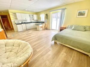 ein großes Schlafzimmer mit einem Bett und einer Küche in der Unterkunft Privacy @ Bras d’Or Lakes Sun House Chalet in St. Peter's