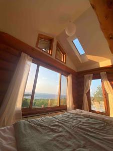 ein Schlafzimmer mit einem Bett und einem großen Fenster in der Unterkunft Privacy @ Bras d’Or Lakes Sun House Chalet in St. Peter's