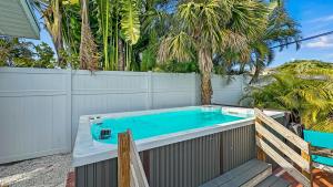 a hot tub in a backyard with a fence and trees at Pelicans Place - 117A in Siesta Key