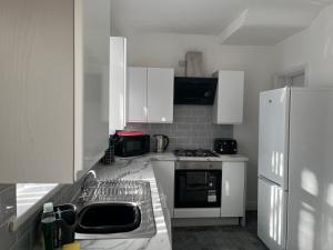 una cucina con armadi bianchi e piano cottura di 2 Bed Property with parking a Liverpool