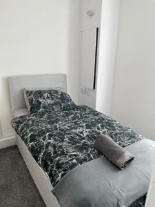 un letto con piumone bianco e nero in una camera da letto di 2 Bed Property with parking a Liverpool